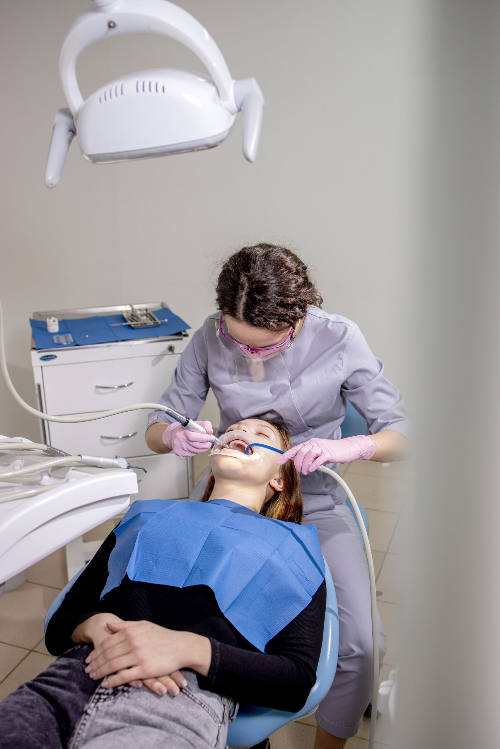 Polishing teeth. Dental Services. Dentist making professional teeth cleaning female young patient at the dental office. Close-up plan